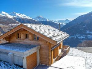 a log cabin with snow on the roof at Chalet Falcons Nest in Hérémence