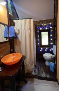 a bathroom with a toilet and a window at Cabaña Costa Azul Los Acantilados in Mar del Plata
