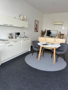 eine Küche mit einem Tisch und Stühlen im Zimmer in der Unterkunft Doppelzimmer im Strandhaus 2 in Elsterheide