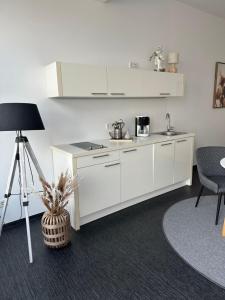 a kitchen with white cabinets and a tripod in a room at Doppelzimmer im Strandhaus 2 Grundbelegung 2 Pers in Elsterheide