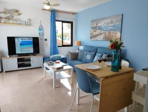 A television and/or entertainment centre at Casa del Mar Air-conditioned Apartment with Swimming Pools - Corralejo Playa