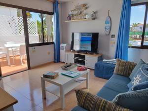 A television and/or entertainment centre at Casa del Mar Air-conditioned Apartment with Swimming Pools - Corralejo Playa