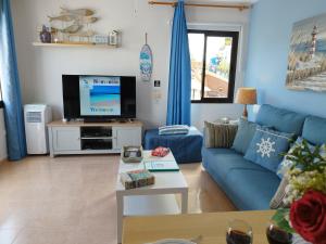 A television and/or entertainment centre at Casa del Mar Air-conditioned Apartment with Swimming Pools - Corralejo Playa