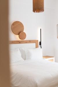 a bedroom with a white bed with a wooden headboard at Spitarona Town House - Largest VIlla in the Center in Mikonos