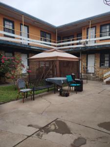 una mesa de picnic y bancos frente a un edificio en Rosenberg Motel, en Galveston