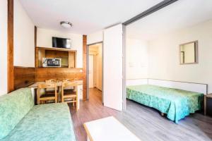 um quarto com duas camas e uma mesa e cadeiras em L'Aiguille - maeva Home - 2 Pièces 5 Personnes Confort 39 em Chamonix-Mont-Blanc
