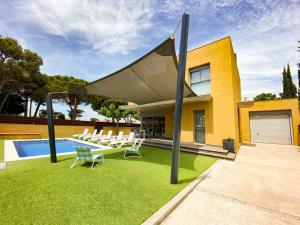 un patio con mesa, sillas y piscina en Villa Alegria, en L'Escala