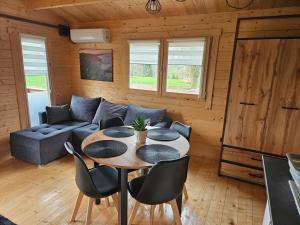 a living room with a table and a couch at Domki Letniskowe przy Strażnicy in Wünschelburg