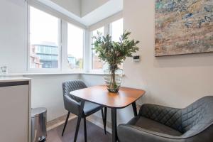 een kamer met een tafel en twee stoelen en een vaas met een plant bij Exquisite Studio - Heart of Reading Centre in Reading