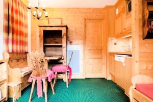 cocina con paredes de madera, mesa y sillas en Résidence Les Sentiers du Tueda - maeva Home - 2 Pièces 4 Personnes Sélect 11, en Les Allues