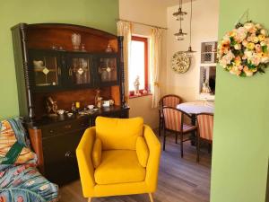 uma sala de estar com uma cadeira amarela e uma mesa em Sashalom Apartman em Budapeste