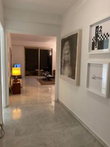 - un couloir avec un salon orné de peintures murales dans l'établissement 2-Room 60 m², Panoramic view, 2 balconies, 50m Pool, à Cagnes-sur-Mer