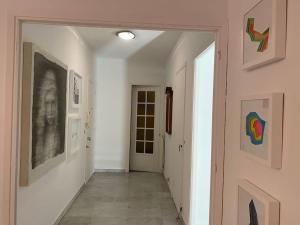 un couloir avec des œuvres d'art sur les murs et un couloir avec une porte dans l'établissement 2-Room 60 m², Panoramic view, 2 balconies, 50m Pool, à Cagnes-sur-Mer
