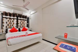 ein Schlafzimmer mit einem großen Bett mit roten Kissen in der Unterkunft OYO Nova Hotel Nildeep in Rajkot