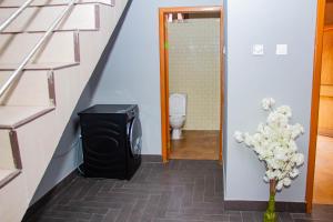 a bathroom with a toilet and a television in a hallway at Accra cosy homes - Krokobite Beach in Tokuse