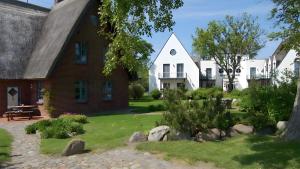 una casa con un patio de hierba delante de ella en Hotel Zur alten Schmiede en Schaprode