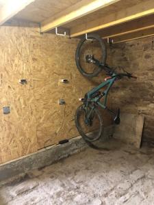 una bicicletta è appesa al muro di un garage di Résidence Merlin Appartement Arthur a Saint-Malon-sur-Mel