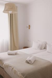 two beds in a room with towels on them at Pure Fonte Velha B&B in Vila do Bispo