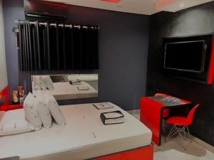 Cassino Motel 4 في سانتو أندريه: غرفة نوم بسرير وكرسي احمر