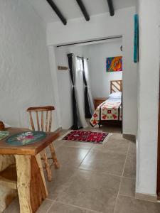 uma sala de estar com uma mesa e uma cama em Apartaestudios La Baranda em Salento