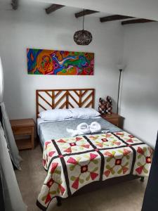 a bedroom with a bed with two towels on it at Apartaestudios La Baranda in Salento