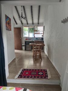 a dining room with a table and a kitchen at Apartaestudios La Baranda in Salento