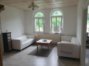 a living room with two couches and a coffee table at Im Herzen des Elbsandsteingebirges in Königstein an der Elbe