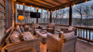 a screened in porch with wicker furniture and a television at All Your'n in Blue Ridge