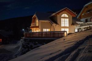 ein Haus auf einem schneebedeckten Hügel in der Nacht in der Unterkunft Ferienhaus in Sankt Margarethen Im Lungau mit Garten, Terrasse und Whirlpool in Sankt Margarethen im Lungau