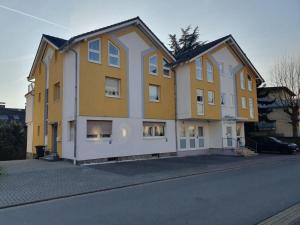 a yellow and white house on the side of a street at ABM Apartment 35 in Zwingenberg