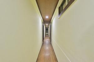 un pasillo largo con suelo de madera y paredes blancas en OYO Hotel Sree Balaji Residency, en Bodakdev