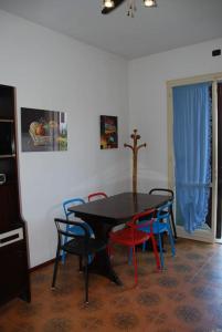 uma sala de jantar com uma mesa preta e cadeiras em Casa Righini, a 2 passi dal mare em Lido di Savio
