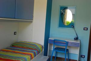 um quarto com uma cama, uma secretária e uma cadeira em Casa Righini, a 2 passi dal mare em Lido di Savio