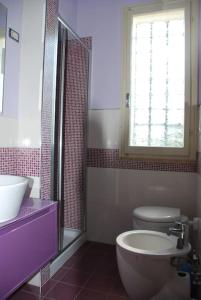 uma casa de banho com um lavatório, um WC e uma janela. em Casa Righini, a 2 passi dal mare em Lido di Savio