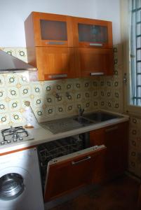 uma cozinha com um lavatório e uma máquina de lavar roupa em Casa Righini, a 2 passi dal mare em Lido di Savio