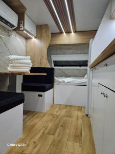 una cocina con armarios blancos y una cama. en יהליס קראונים נגררים השכרת קראוונים en Baraq
