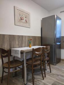 a kitchen with a table with chairs and a refrigerator at Pod Lasem in Nowe Miasto Lubawskie