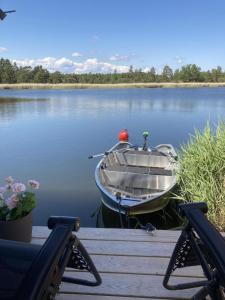 ein Boot auf dem Wasser neben einem Dock in der Unterkunft Ferienhaus für 8 Personen ca 50 m in Rockneby, Südschweden Schärengarten der Südostküste in Rockneby