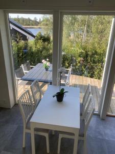 einen weißen Esstisch und Stühle auf einer Terrasse in der Unterkunft Ferienhaus für 8 Personen ca 50 m in Rockneby, Südschweden Schärengarten der Südostküste in Rockneby