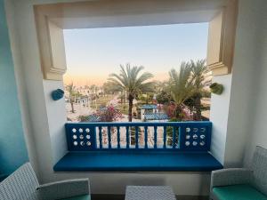 een balkon met een blauwe bank en palmbomen bij Marina Retreat in Hammamet