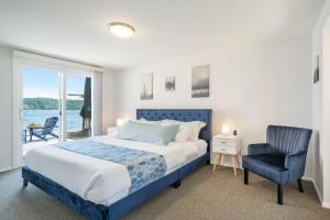 1 dormitorio con 1 cama, 1 silla y 1 ventana en 116 - Inviting Waterfront Haven BBQ, en Gig Harbor