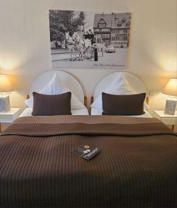 um quarto com duas camas com um controlo remoto na cama em Hotel-Restaurant Thüringer Hof em Bad Frankenhausen