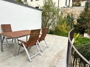 a wooden table and chairs on a patio at Select-Home 4 Schwandorf - Geräumig - Küche - Netflix - Zentral in Schwandorf in Bayern