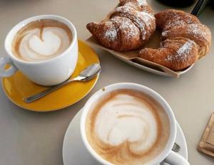 two cups of coffee and pastries on a table at Dolce Dormire in Enna