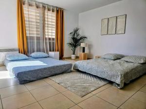 sypialnia z 2 łóżkami i oknem w obiekcie Le Rooftop Saint Charles parking privé w Marsylii