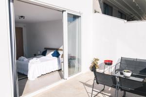 a bedroom with a bed and a balcony with a table and chairs at Bright Penthouse with large terrace in Pieta