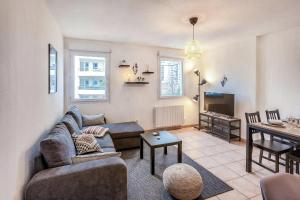 a living room with a couch and a table at Cosy appartement - Parking Privé Gratuit in Chambéry