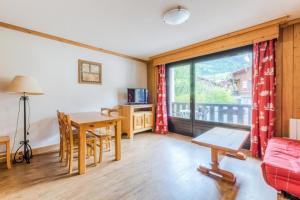 a living room with a table and a window at Résidence Les Balcons d'Anaïte - maeva Home - Studio Cabine 5/6 Personnes C 63 in Les Houches