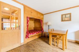 a bedroom with a table and a bed in a room at Résidence Les Balcons d'Anaïte - maeva Home - Studio Cabine 5/6 Personnes C 63 in Les Houches