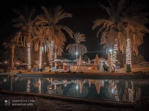a swimming pool at night with palm trees at lasirena mini egypt in Ain Sokhna